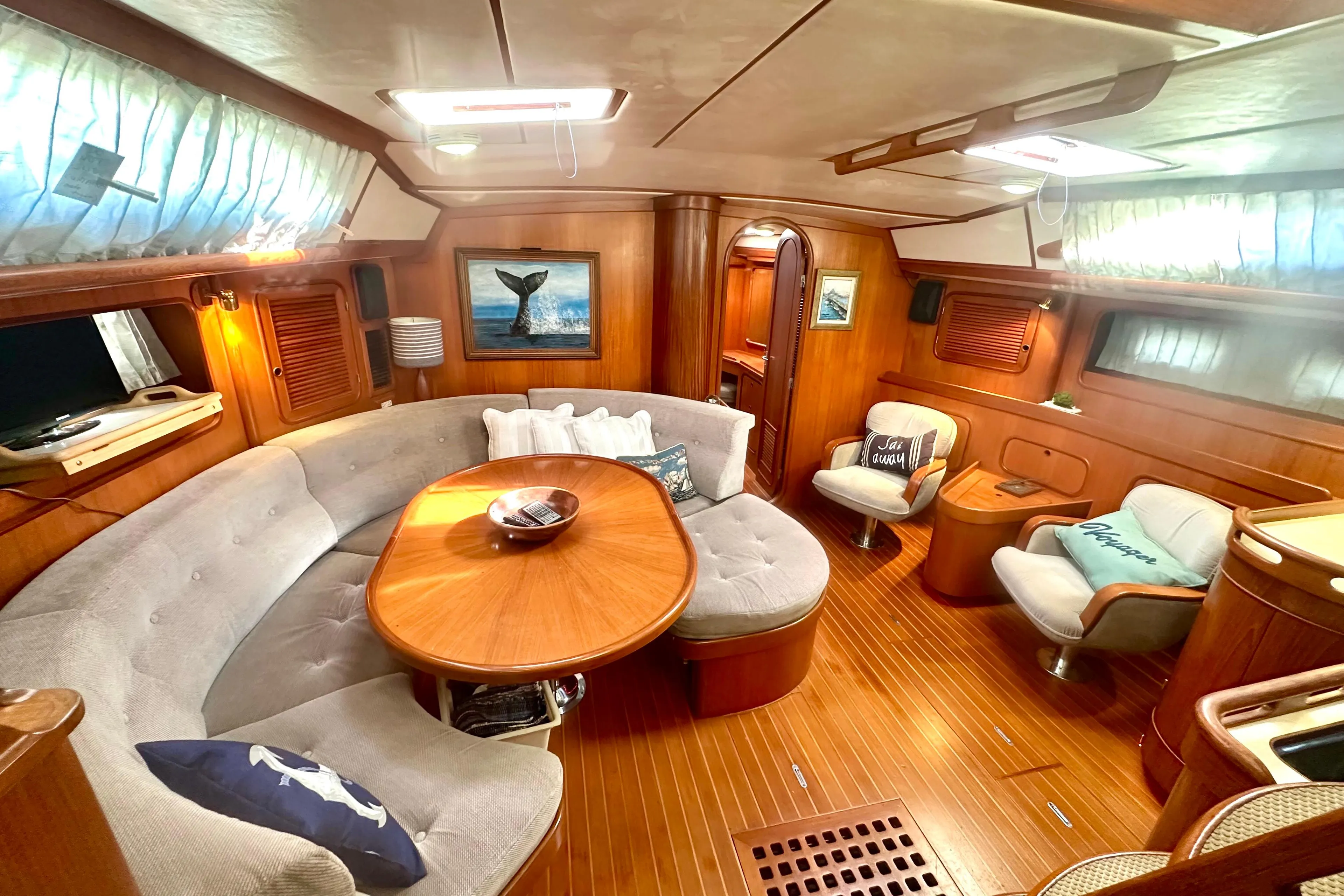 Luxurious 1991 Taswell Sloop interior with elegant wood finish and cozy seating area.