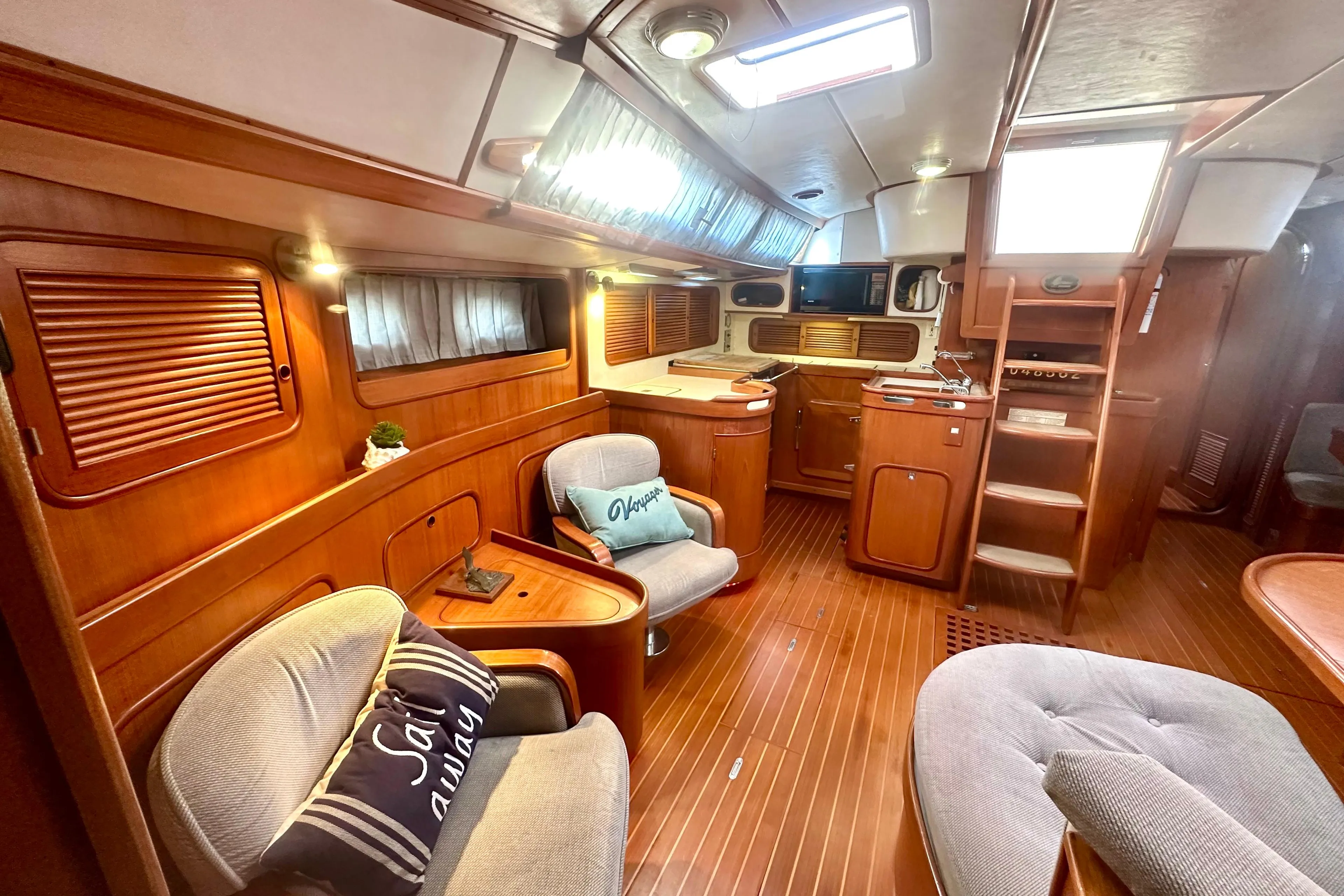 Luxurious 1991 Taswell Sloop interior with elegant wood finish and cozy seating area.