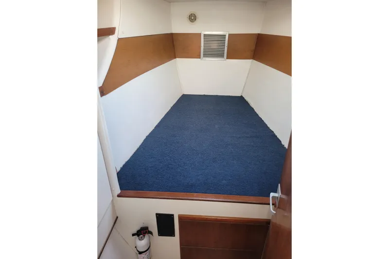 Ki Zen Yacht Photos Pics Interior cabin of 1995 Lagoon TPI boat with blue carpet and wooden accents.