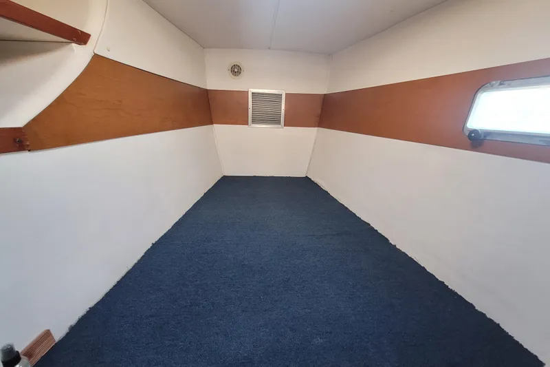 Ki Zen Yacht Photos Pics Interior of a 1995 Lagoon TPI boat with blue carpet and wood accents.