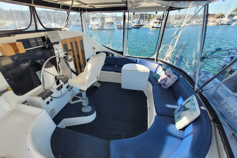 Ki Zen Yacht Photos Pics Interior of a 1995 Lagoon TPI yacht with steering wheel and blue seating.