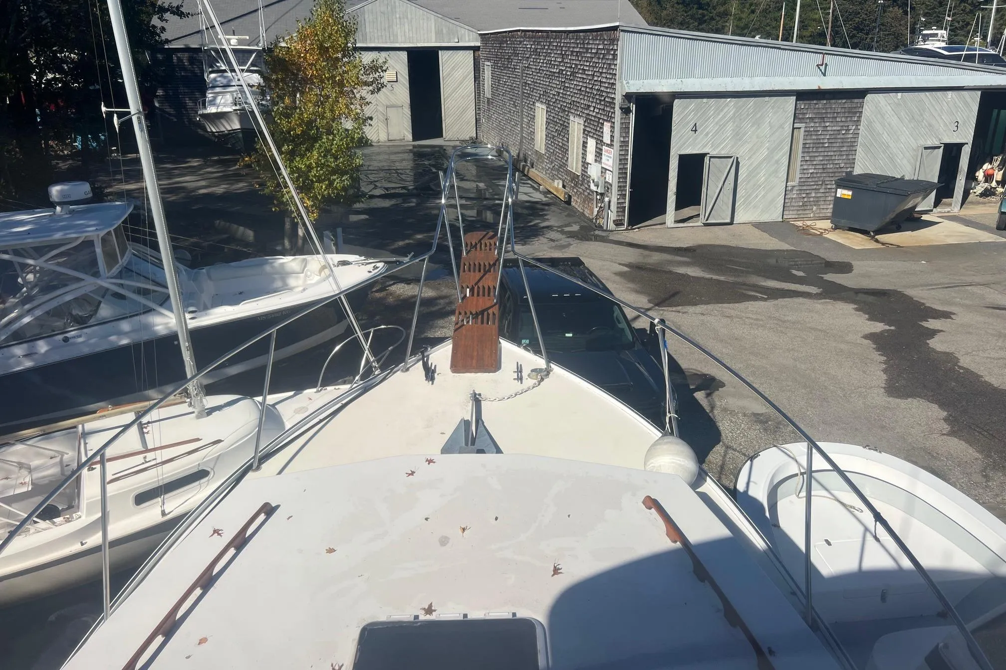 1995 Young Brothers 38 Fly Bridge boat docked at a marina with nearby buildings.