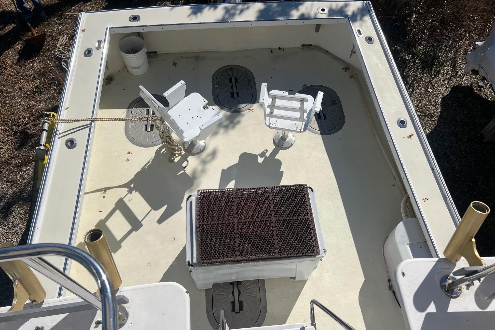 Deck view of 1995 Young Brothers 38 Fly Bridge boat with fishing chairs and equipment.