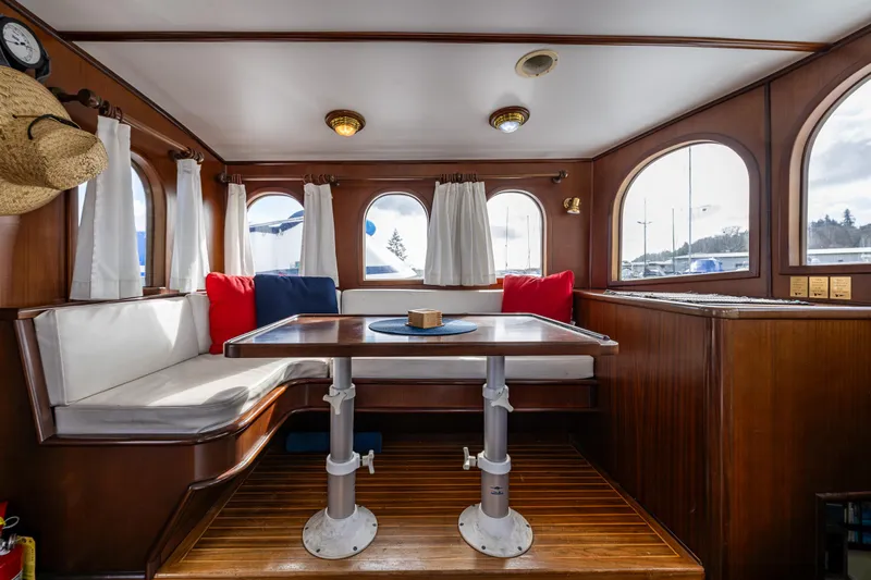Zeta Yacht Photos Pics Cozy dining area in 2009 Diesel Duck 41-Plus boat with wooden interior and cushioned seating.