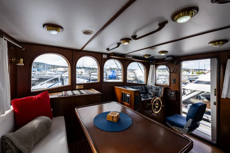 Zeta Yacht Photos Pics Pilothouse interior of 2009 Diesel Duck 41-Plus yacht, featuring wood paneling and marina view.