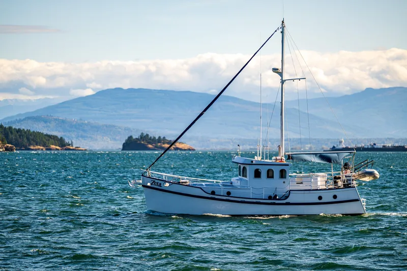 Zeta Yacht Photos Pics 2009 Diesel Duck 41-Plus yacht sailing on scenic blue waters with mountainous backdrop.