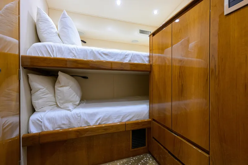 Osh-it Yacht Photos Pics Bunk beds in 2014 Viking 76 Enclosed Bridge Convertible yacht cabin, featuring wooden cabinetry.