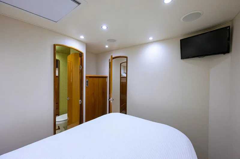 Osh-it Yacht Photos Pics Interior of 2014 Viking 76 Enclosed Bridge Convertible yacht bedroom with TV and bathroom.