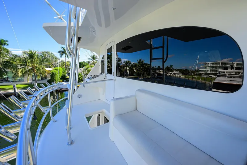 Osh-it Yacht Photos Pics 2014 Viking 76 Enclosed Bridge Convertible yacht deck with white seating and marina view.