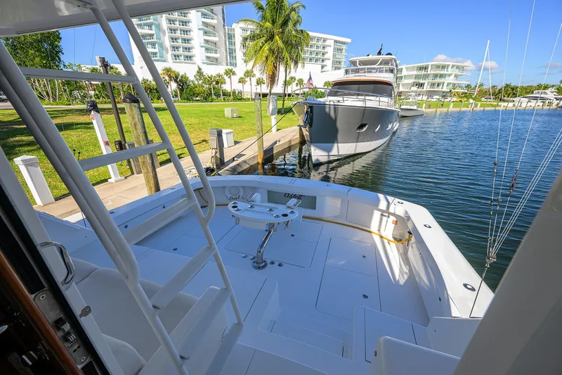 Osh-it Yacht Photos Pics 2014 Viking 76 Enclosed Bridge Convertible yacht docked near luxury waterfront buildings.