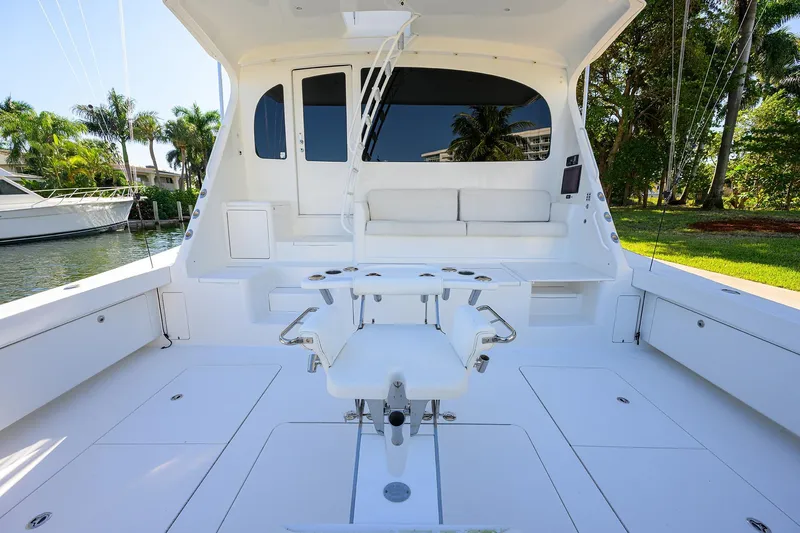 Osh-it Yacht Photos Pics 2014 Viking 76 Enclosed Bridge Convertible yacht cockpit with seating and fishing chair.
