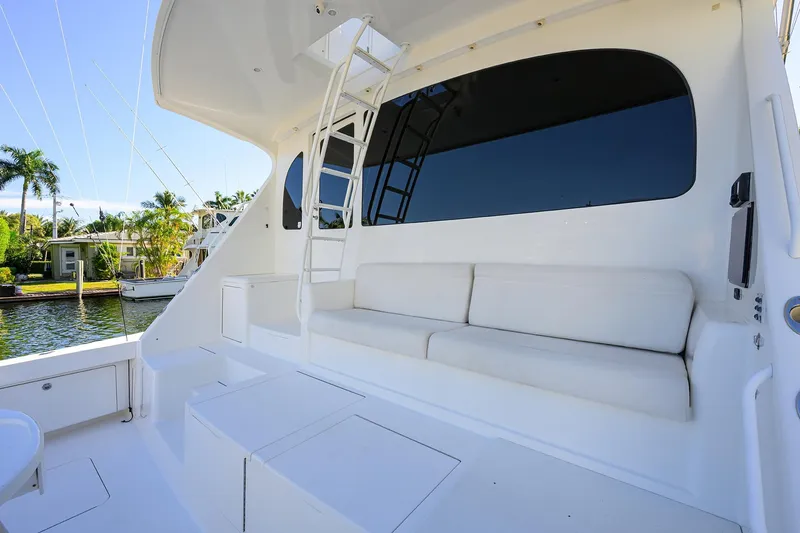Osh-it Yacht Photos Pics 2014 Viking 76 Enclosed Bridge Convertible yacht with white seating and ladder.