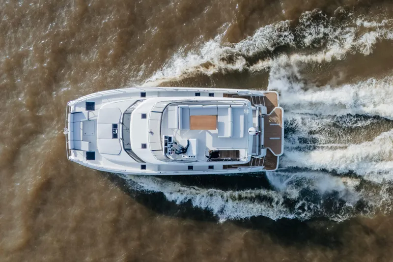  Yacht Photos Pics Aerial view of 2023 Prestige M48 Power Catamaran cruising on water.