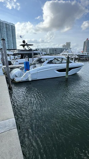  Yacht Photos Pics 2021 Cruisers Yachts 42 GLS docked at marina with cityscape background.