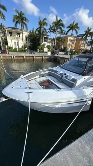  Yacht Photos Pics 2021 Cruisers Yachts 42 GLS docked by waterfront homes, under a clear blue sky.