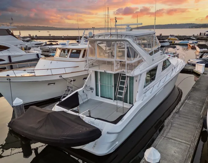 Too Many Options Yacht Photos Pics 1993 Sea Ray 550 Sedan Bridge yacht docked at sunset, featuring spacious deck and elegant design.