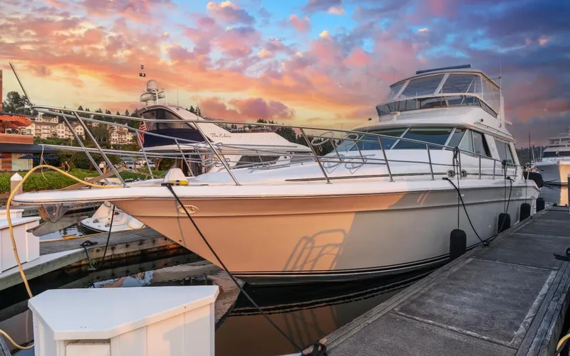 Too Many Options Yacht Photos Pics 1993 Sea Ray 550 Sedan Bridge yacht docked at sunset with vibrant sky.