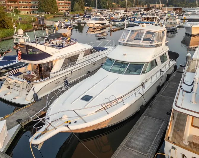 Too Many Options Yacht Photos Pics 1993 Sea Ray 550 Sedan Bridge yacht docked at a marina, surrounded by other boats.