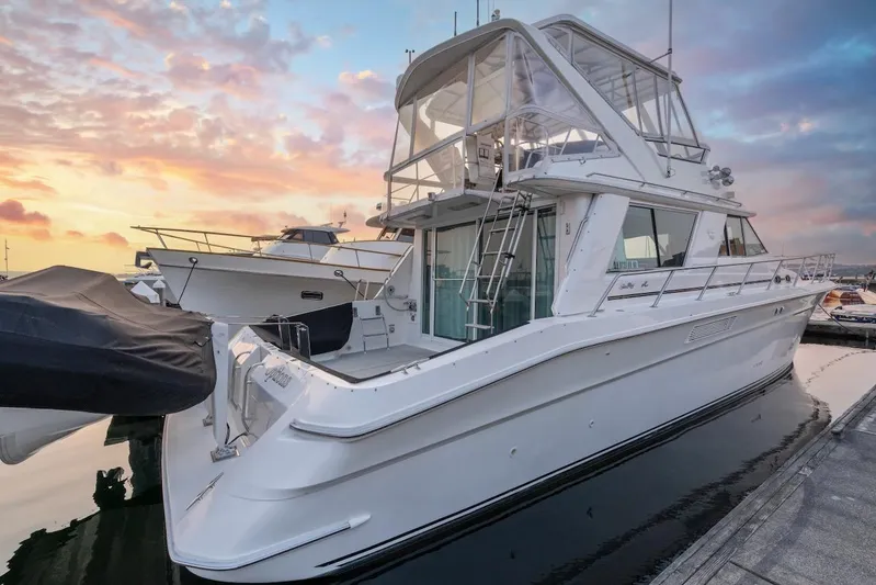 Too Many Options Yacht Photos Pics 1993 Sea Ray 550 Sedan Bridge yacht docked at sunset, showcasing sleek design and spacious deck.