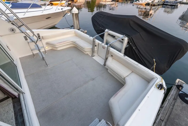 Too Many Options Yacht Photos Pics 1993 Sea Ray 550 Sedan Bridge yacht deck with seating, docked at marina.