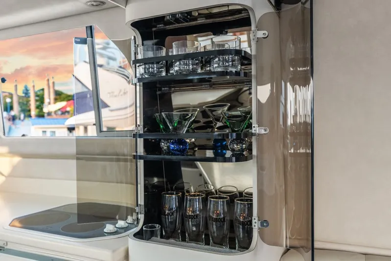 Too Many Options Yacht Photos Pics 1993 Sea Ray 550 Sedan Bridge interior with glassware cabinet and scenic marina view.