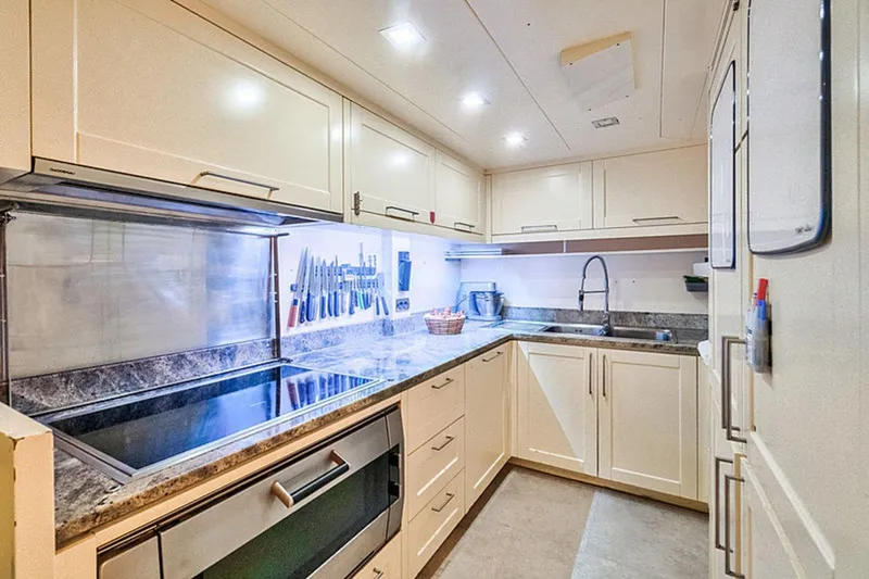 M/y Balkan Yacht Photos Pics Modern yacht kitchen with sleek cabinets, stainless steel appliances, and under-cabinet lighting, Falcon 102, 2007.