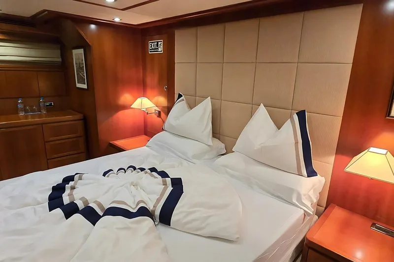 M/y Balkan Yacht Photos Pics Luxurious cabin interior of 2007 Falcon 102 yacht with elegant bedding and warm lighting.