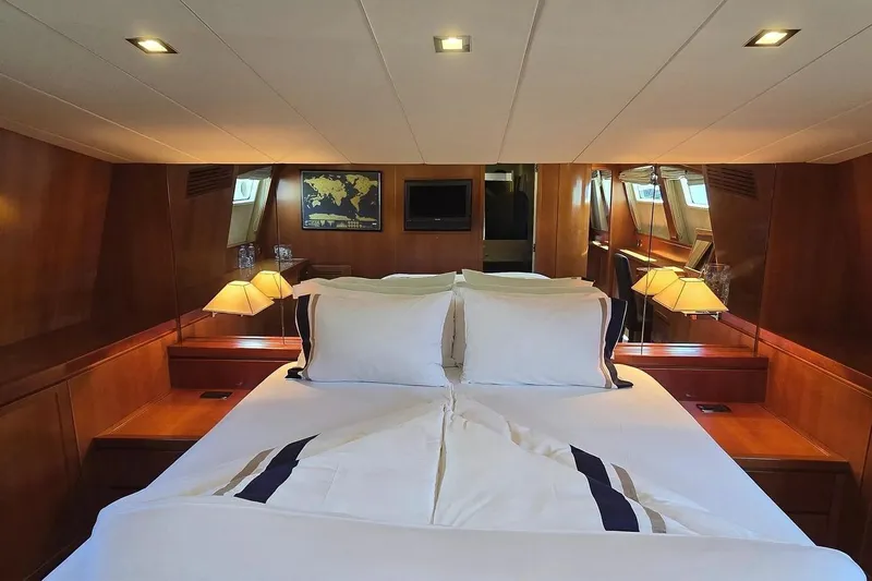 M/y Balkan Yacht Photos Pics Luxurious cabin interior of 2007 Falcon 102 yacht with elegant wood paneling and cozy bedding.