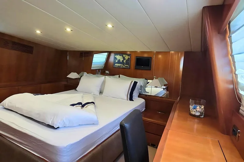 M/y Balkan Yacht Photos Pics Luxurious cabin interior of 2007 Falcon 102 yacht with elegant wood paneling and cozy bedding.