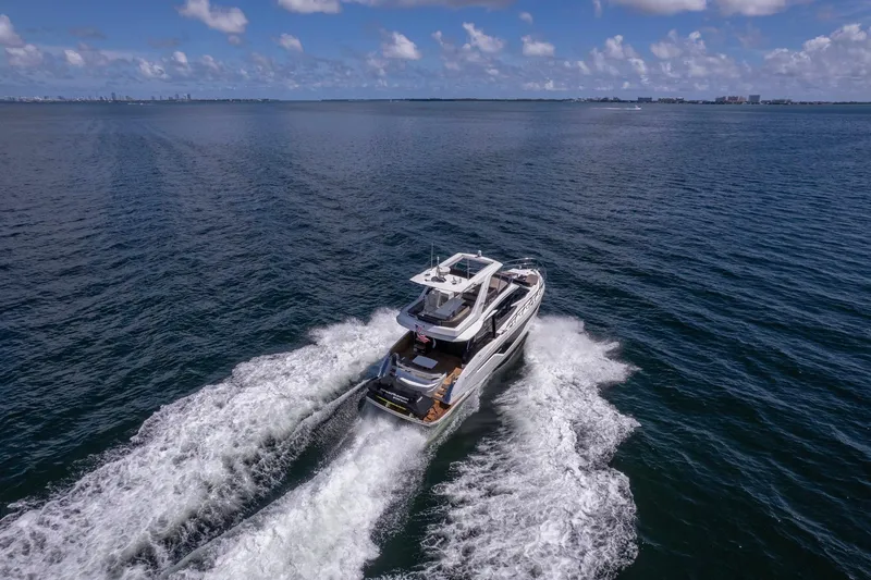 Mangogo Yacht Photos Pics A 2021 Galeon 500 Fly yacht cruising on open water under a clear blue sky.