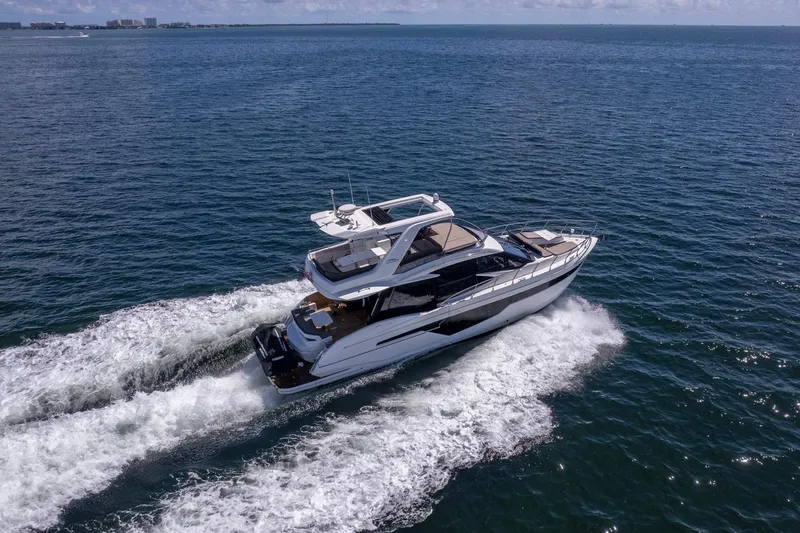 Mangogo Yacht Photos Pics 2021 Galeon 500 Fly yacht cruising on open sea, creating white wake trails.
