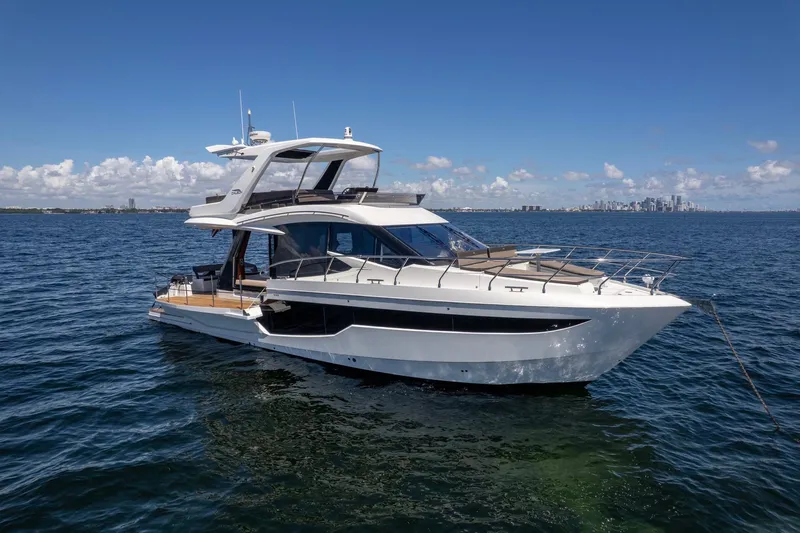 Mangogo Yacht Photos Pics 2021 Galeon 500 Fly yacht on open water with city skyline in background.