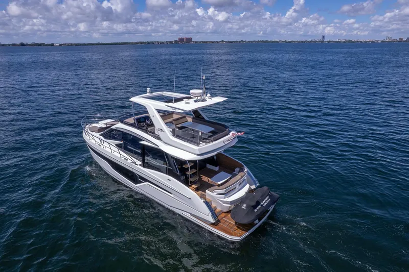 Mangogo Yacht Photos Pics 2021 Galeon 500 Fly yacht cruising on open water under a partly cloudy sky.