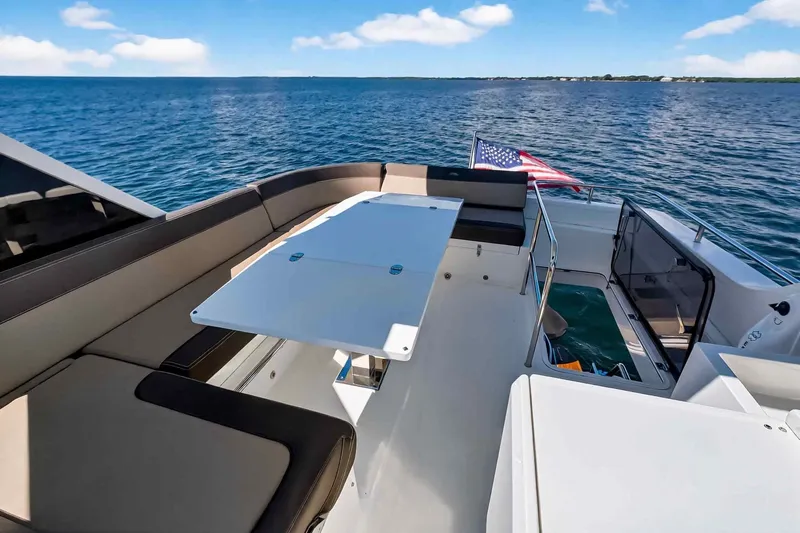 Mangogo Yacht Photos Pics Luxurious 2021 Galeon 500 Fly yacht deck with seating, table, and ocean view.