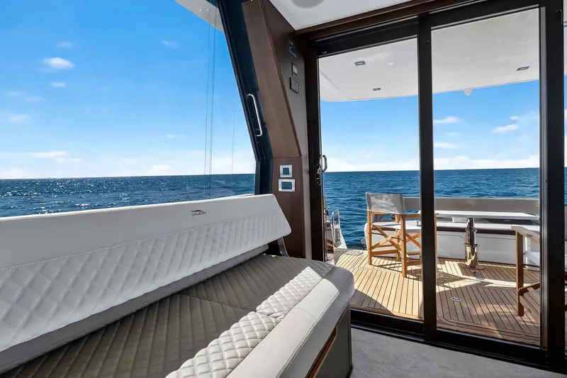 Mangogo Yacht Photos Pics Luxurious interior of 2021 Galeon 500 Fly yacht with ocean view through glass doors.