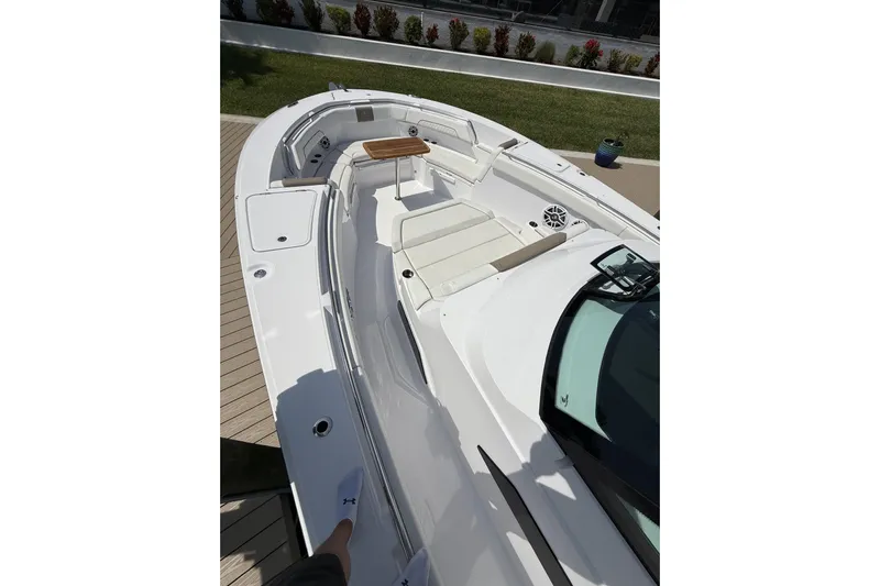  Yacht Photos Pics 2024 Bertram 39 CC boat deck with seating and table, docked outdoors.