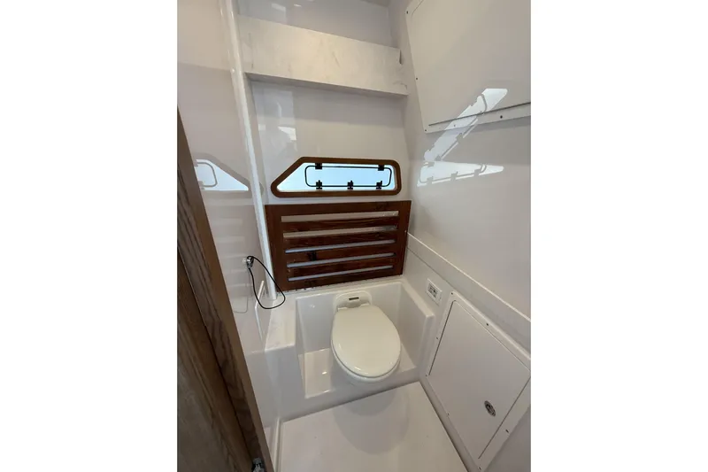  Yacht Photos Pics 2024 Bertram 39 CC boat bathroom with modern fixtures and wooden accents.