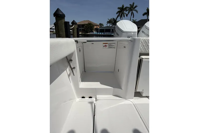  Yacht Photos Pics 2024 Bertram 39 CC boat interior with open storage compartment, docked near palm trees.