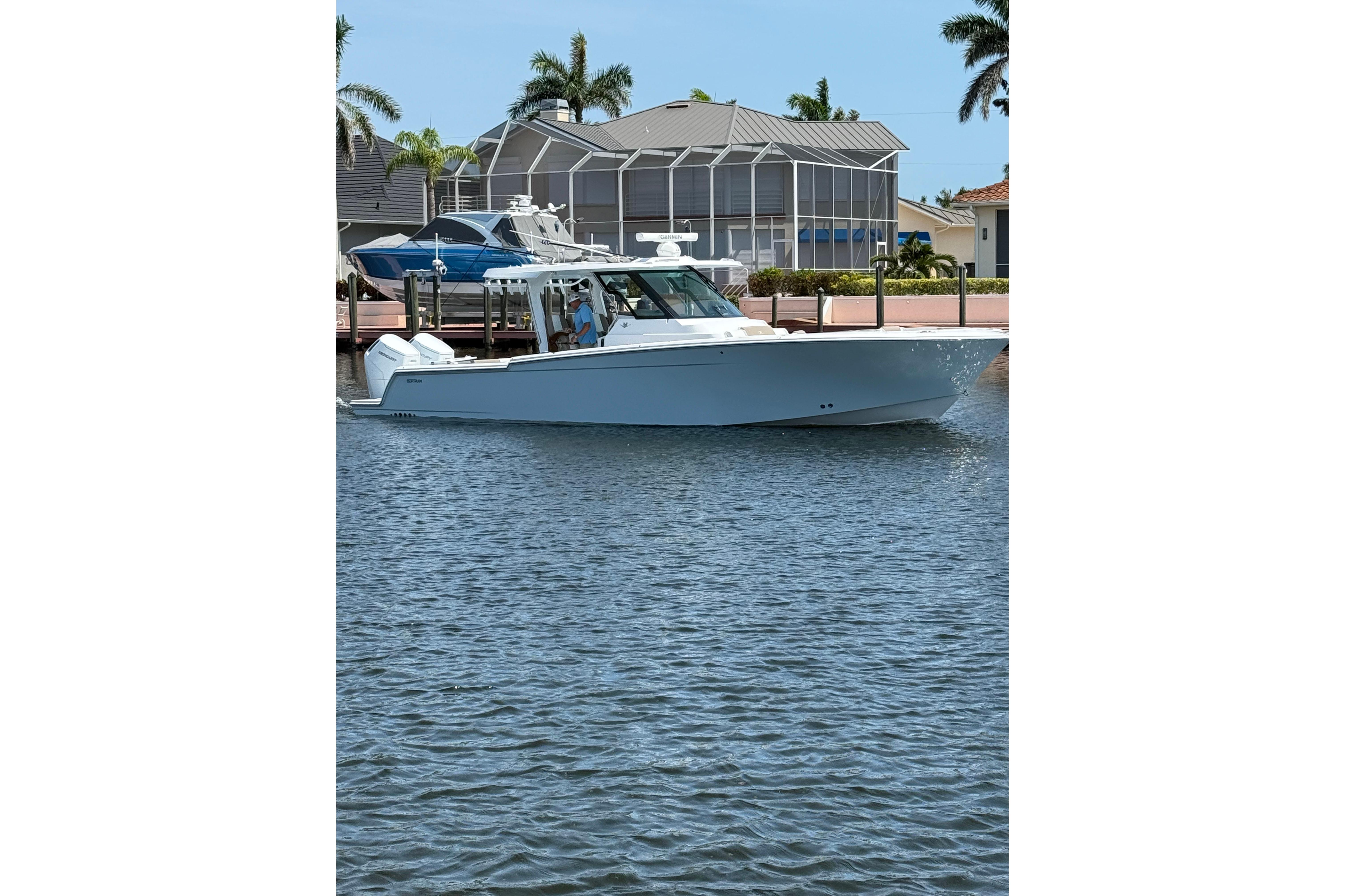 2024 Bertram 39 CC boat on water near waterfront homes and palm trees.