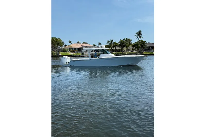  Yacht Photos Pics 2024 Bertram 39 CC boat on calm water with palm trees in the background.