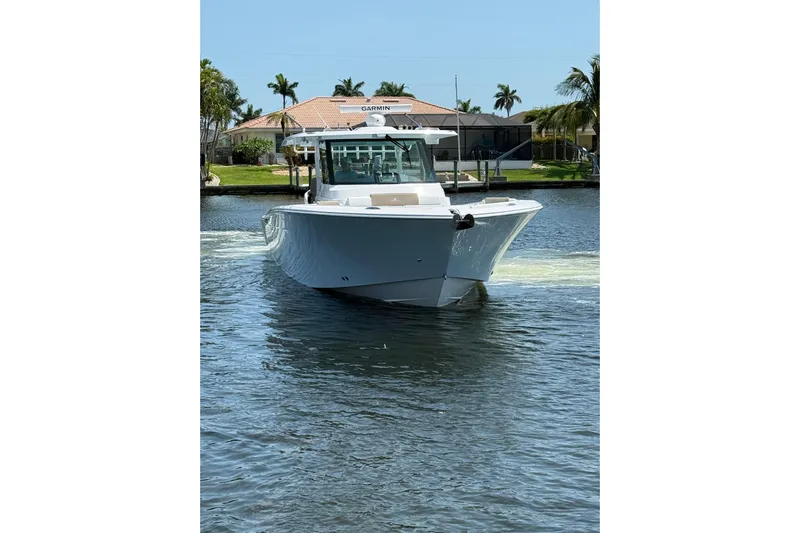  Yacht Photos Pics 2024 Bertram 39 CC boat cruising on a sunny day in a canal.