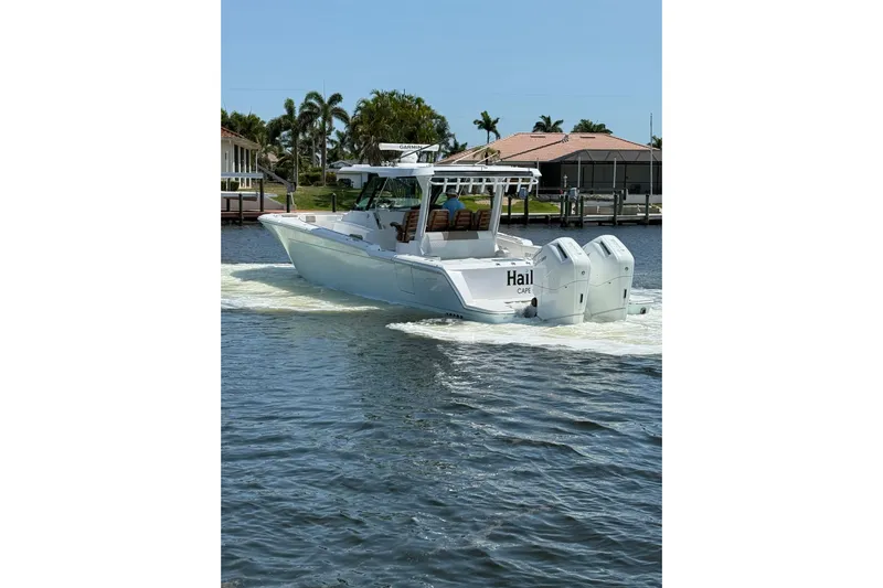  Yacht Photos Pics 2024 Bertram 39 CC boat cruising on a sunny day, featuring dual outboard engines.