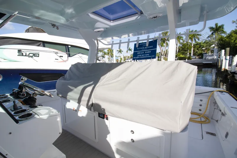  Yacht Photos Pics 2024 Bertram 39 CC boat interior with covered seating and steering wheel.