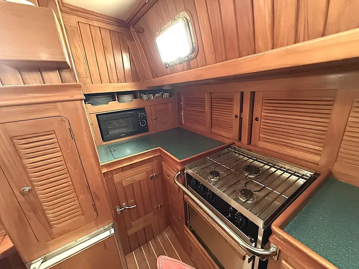 Sarah Yacht Photos Pics Cabo Rico 2000 yacht kitchen with wood cabinetry, stove, and microwave.