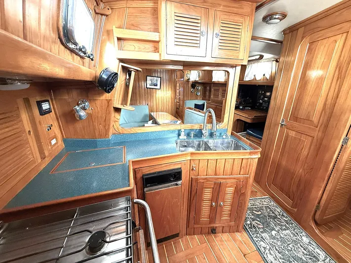 Sarah Yacht Photos Pics Luxurious 2000 Cabo Rico Pearl Edition yacht interior with wooden cabinetry and modern amenities.