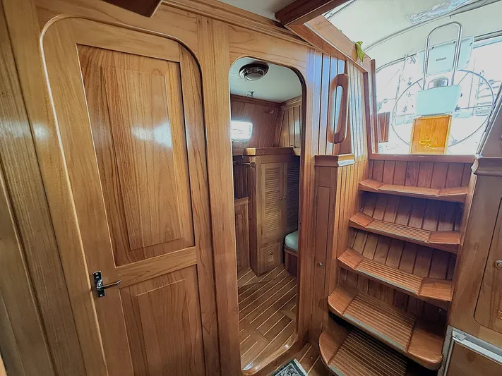 Sarah Yacht Photos Pics Interior of 2000 Cabo Rico Pearl Edition yacht with wooden finishes and staircase.