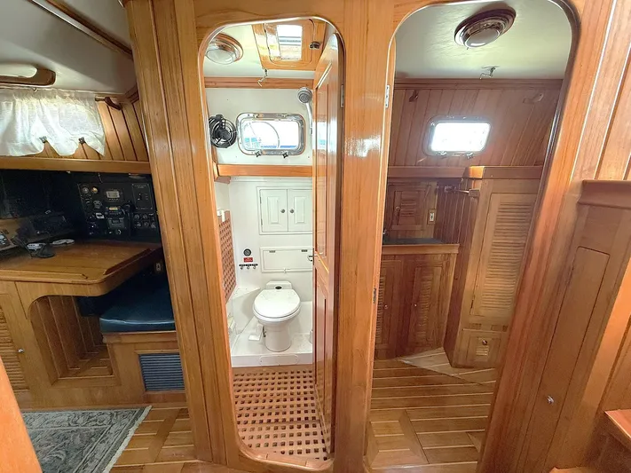 Sarah Yacht Photos Pics Interior of 2000 Cabo Rico Pearl Edition yacht, featuring wooden cabinetry and compact bathroom.