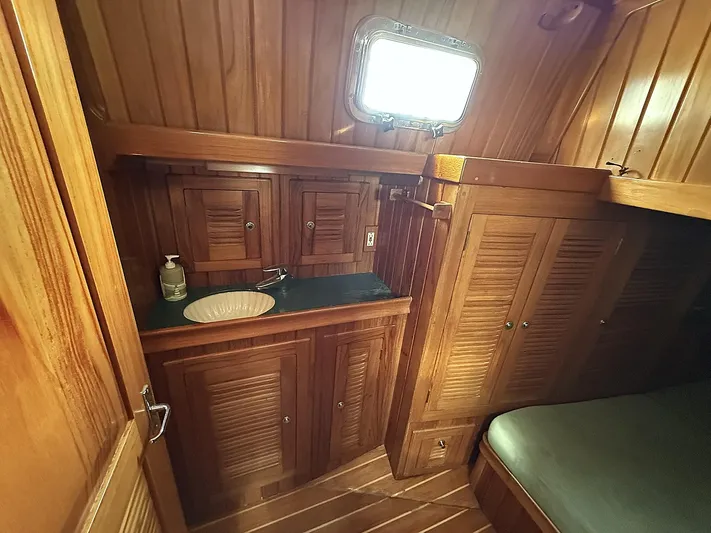Sarah Yacht Photos Pics Interior of 2000 Cabo Rico Pearl Edition yacht with wooden cabinetry and cozy sleeping area.