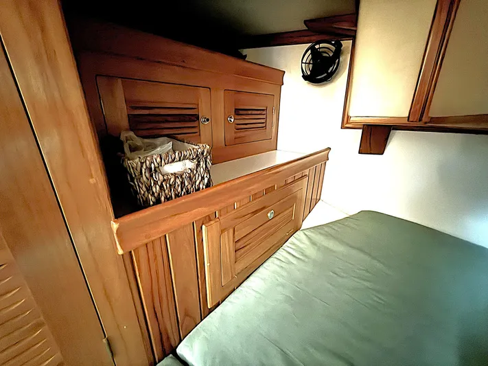 Sarah Yacht Photos Pics Interior of 2000 Cabo Rico Pearl Edition yacht with wooden cabinetry and cozy sleeping area.