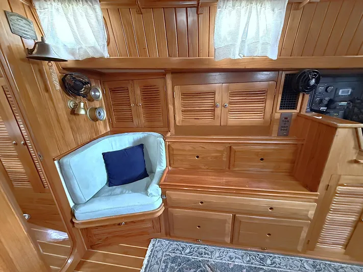 Sarah Yacht Photos Pics Interior of 2000 Cabo Rico Pearl Edition yacht with wooden cabinetry and cushioned seating.